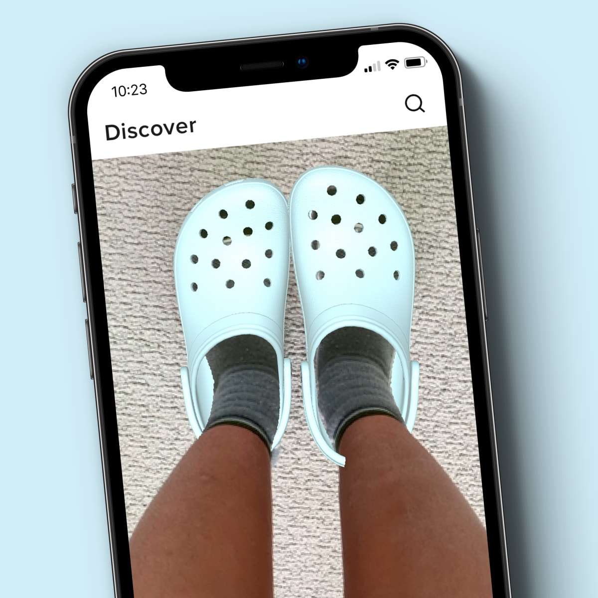 Person wearing teal crocs in a phone on the Crocs app