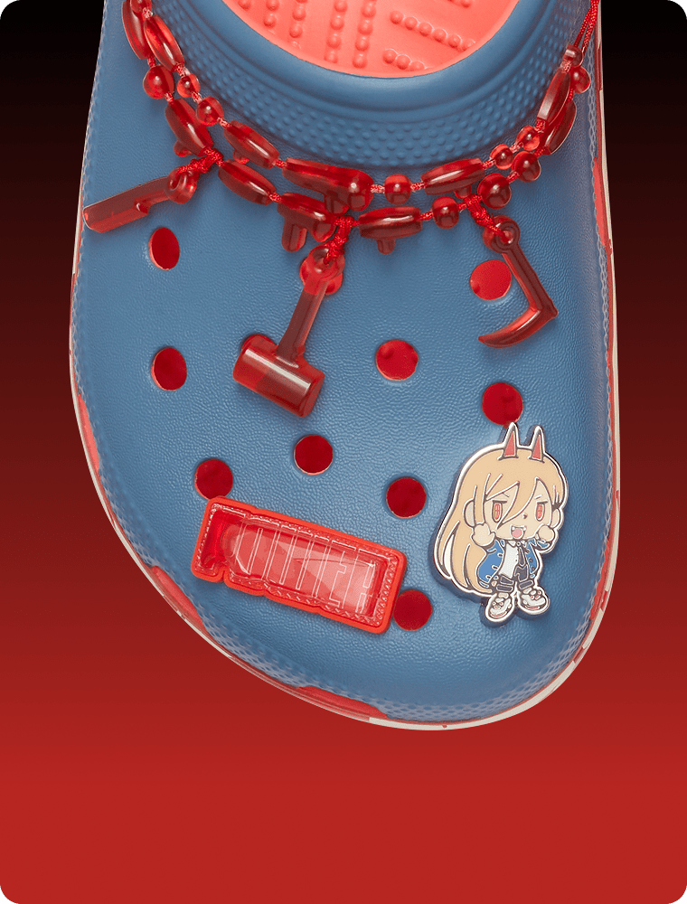 Top view of a blue clog decorated with red chains and oversized character-inspired charms.