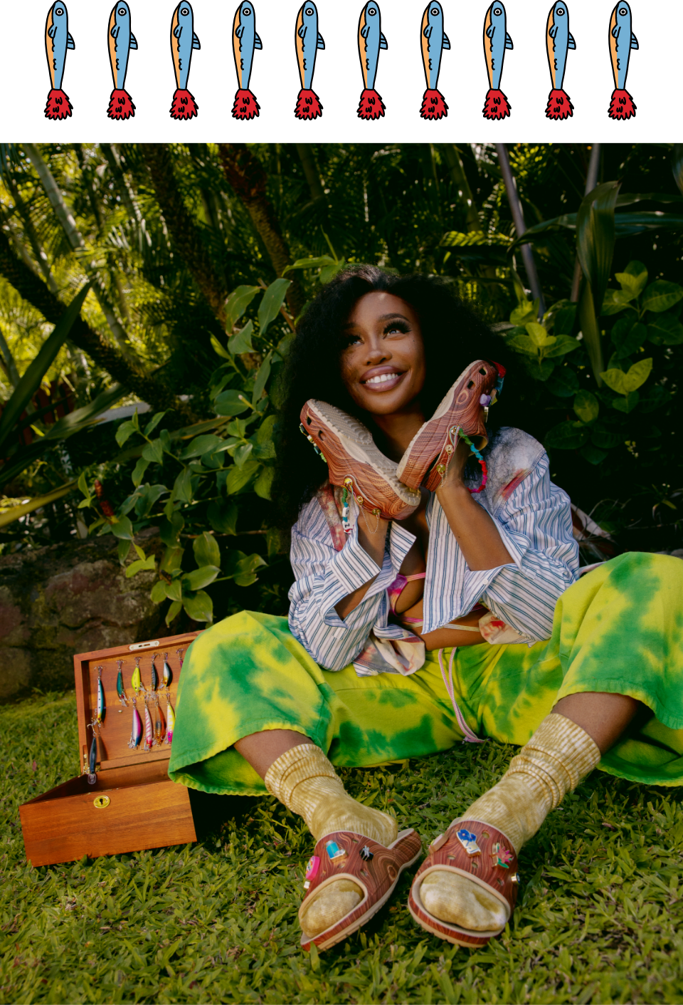 Fishing lure pop-art. Sza posing in natural setting wearing Wood Print Clogs on hands, and Wood Print Slides on Feet.