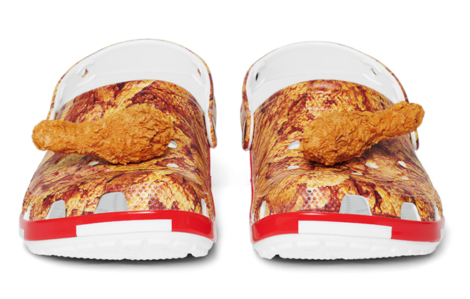 Kentucky Fried Chicken® Classic Clogs with Jibbitz™, on a pile of drumsticks.