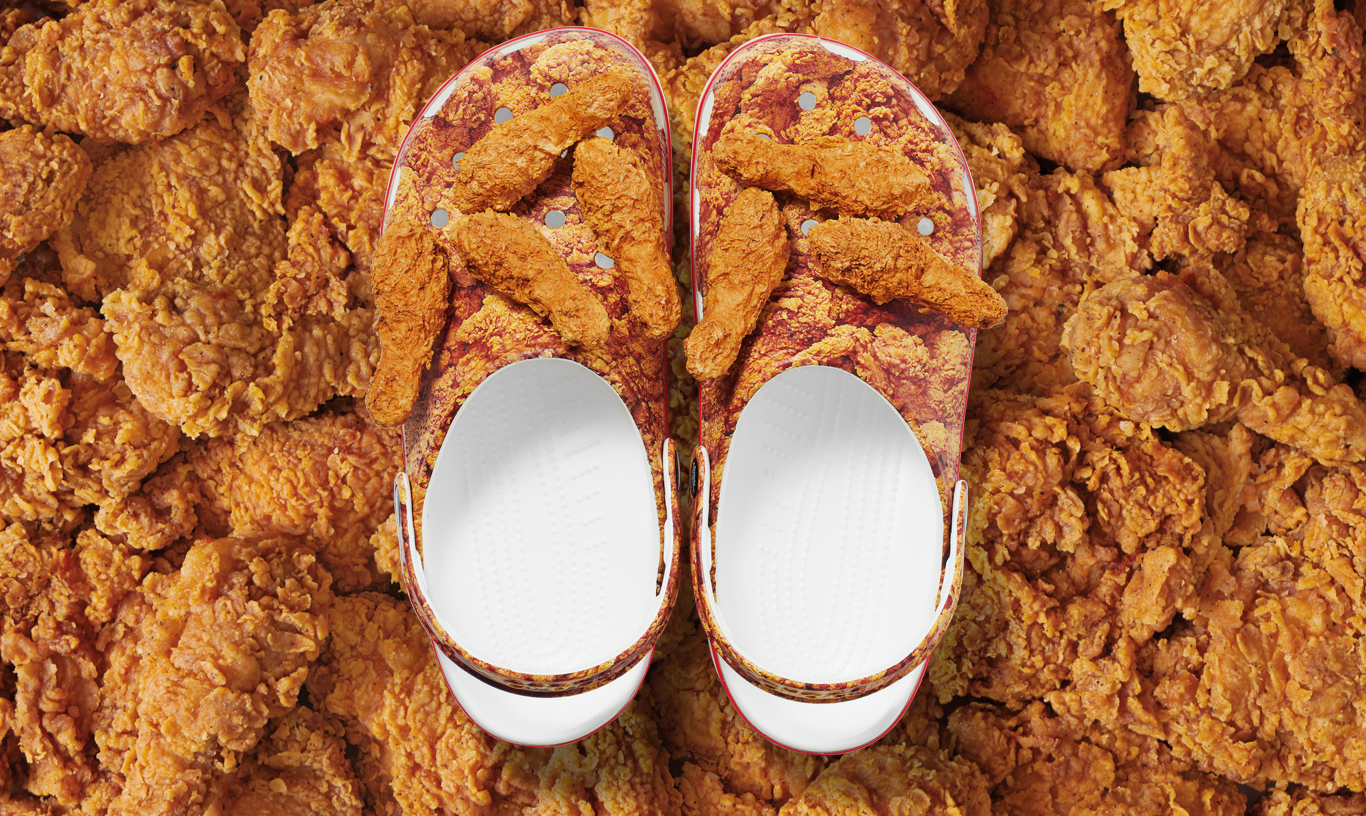 Kentucky Fried Chicken® Classic Clogs with Jibbitz™, on a pile of drumsticks.