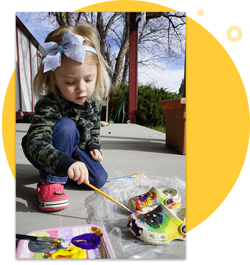 Girl painting Crocs.