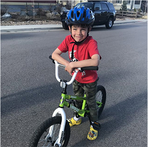 Kid in Crocs riding a bike.